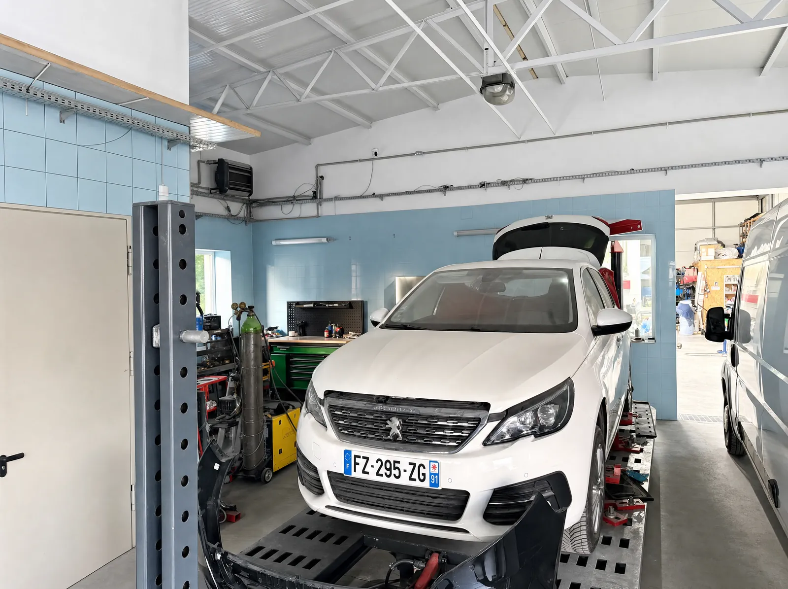 Auto na ramie naprawczej w hali warsztatu Auto-Team